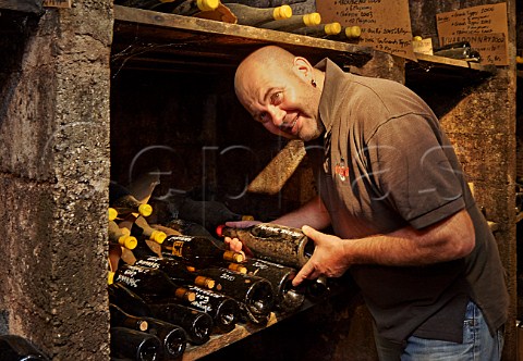 JeanFranois Ganevat with bottle of his Enfant Terrible in his personal cellar  Domaine Ganevat La Combe Rotalier Jura France Ctes du Jura