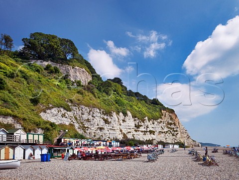 Beach huts caf and deckchairs below the cliffs at Beer South Devon UK