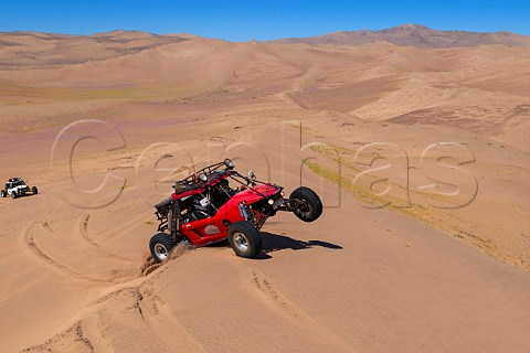 Baja 1000 race cars from The Gentleman Driver company negotiating a sand dune in the Atacama Desert Chile