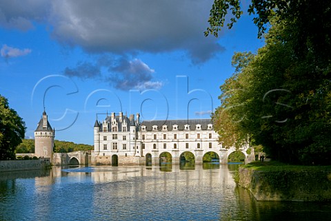 Chteau de Chenonceau over the River Cher with couple walking on footpath Chenonceaux IndreetLoire France