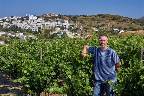 Thanos Georgilas Associate Winemaker with Avgoustiatis vines in Agios Dimitrios vineyard of TOinos with village of Falatados beyond Tinos Greece