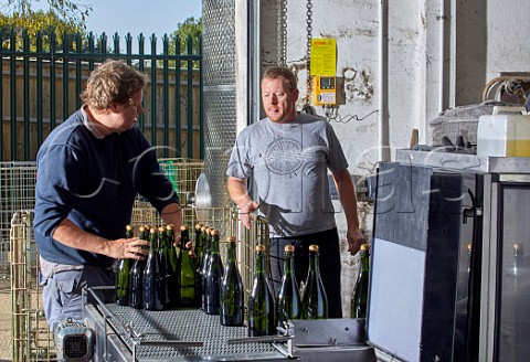 Marcus Rayner winemaker right The bottles are coming out of the disgorging dosage and corking machine  Wiston Estate winery Washington Sussex England
