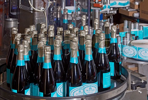 Bottles of Wiston Estate sparkling wine on the labelling machine  Washington Sussex England