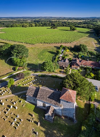 The 11thcentury church of St Mary the Virgin with Stopham Estate Vineyard beyond and the South Downs in the distance Stopham Sussex England