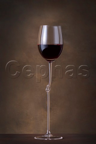 Tall glass of red wine with knot in the stem