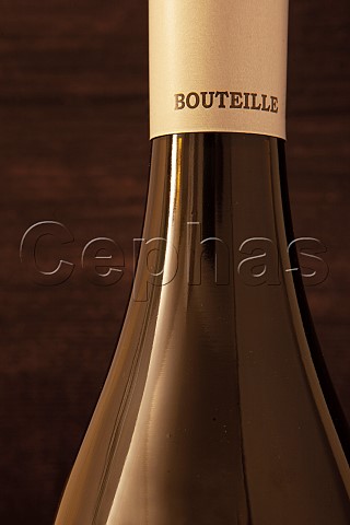 The neck of a Burgundy wine bottle showing the bottom of the capsule with the word bouteille the French for bottle on it